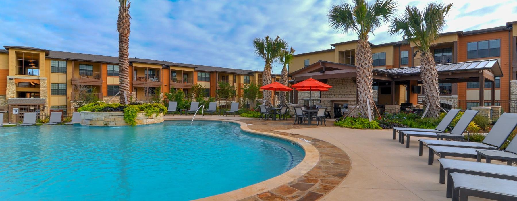 a pool with lounge chairs around it
